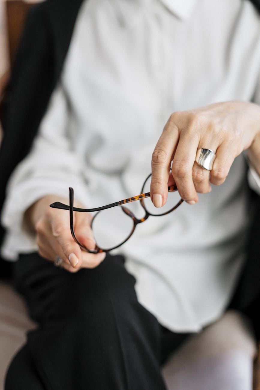 person holding brown framed eyeglasses